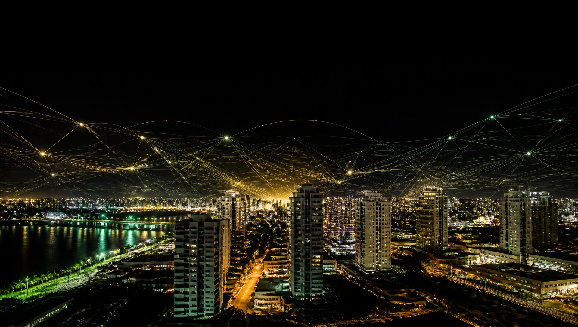 Skyline de Aracaju à noite conectada por uma rede luminosa de dados